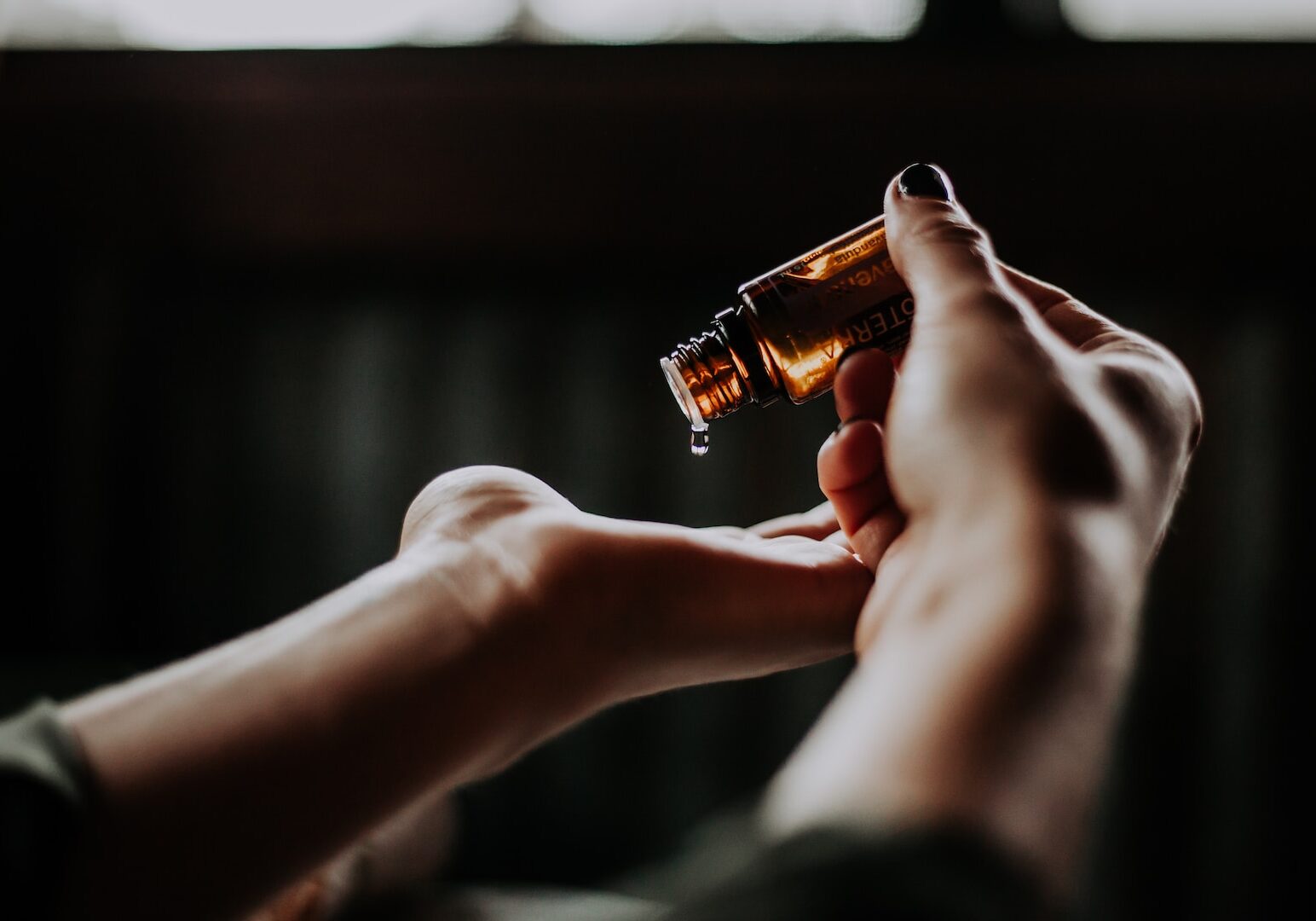 Photo by Christin Hume person holding amber glass bottle